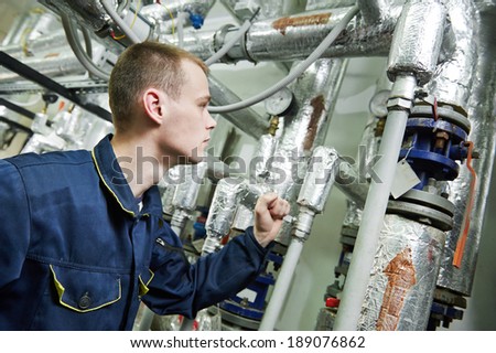 repairman engineer or inspector of fire engineering system or heating system with valve equipment in a boiler house