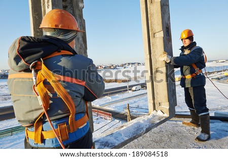 Team of builder worker in safety protective equipment at winter construction site