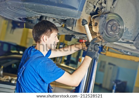 garage auto mechanic repairman checking car brake during automobile maintenance at repair service station