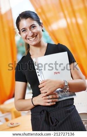 happy smiling waitress girl of commercial restaurant in uniform waiting an order with menu