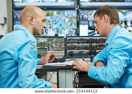 two security guards watching video monitoring surveillance security system