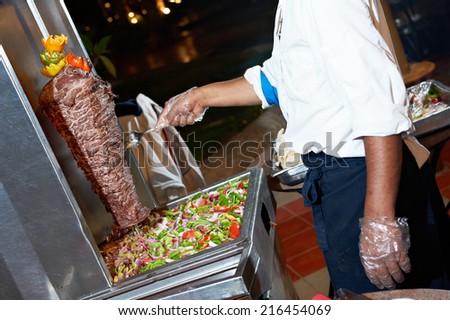 Arab chef in cook uniform making kebab with meat and vegetables