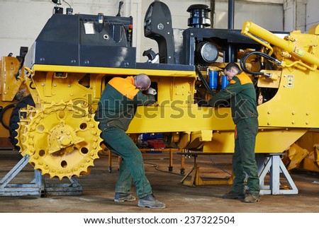 industrial worker during heavy industry machinery assembling on production line manufacturing workshop at factory
