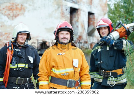 firefighter crew in uniform in front of fire engine machine and fireman team