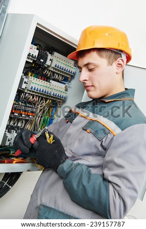 electrician builder engineer worker working with cable in fuse switch box