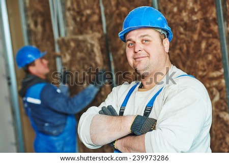cheerful plasterer worker at a indoors wall insulation works