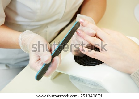 Manicure nail technician worker perfoming procedure for hand care in beauty salon
