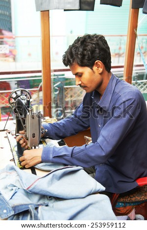 Portrait of two indian man tailor at work place with sewing machine