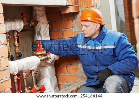 repairman engineer of engineering system or heating system installer open the valve equipment in a boiler house