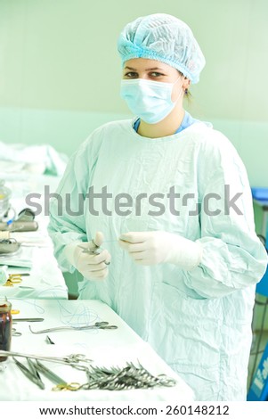 surgeon assistant nurse in uniform during heart transplantation operation on a patient at cardiac surgery clinic