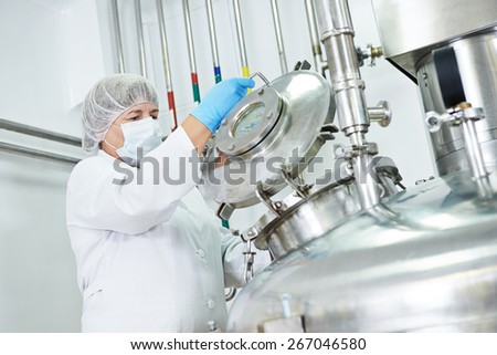 female worker operating pharmaceutical factory equipment mixing tank on production line in pharmacy industry manufacture factory