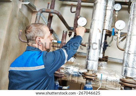 repairman plumber engineer of fire engineering system or heating system open the valve equipment in a boiler house