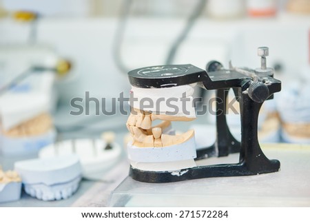 prosthetic dentistry concept. Articulator with dental prosthesis model in laboratory