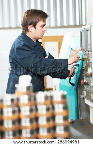 industrial worker near cnc milling machine center at factory tool workshop
