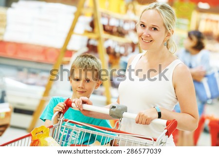 woman and little boy son during shopping at supermarket store
