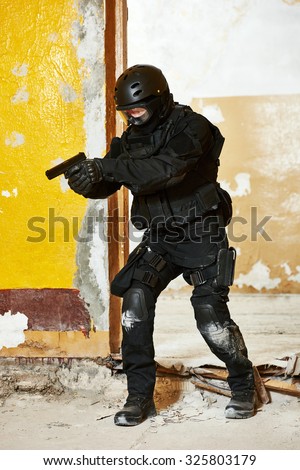 Military industry. Special forces or anti-terrorist police soldier,  private military contractor armed with pistol ready to attack during clean-up operation, mission