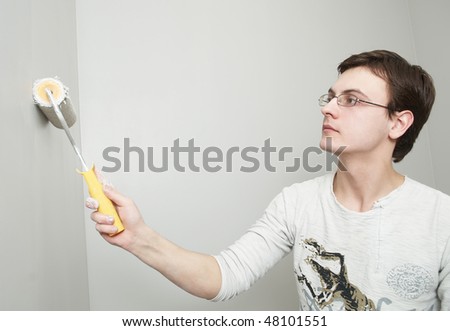 Painter worker hand at decoration work painting a wall with roller