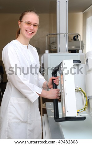 smiling x-ray laboratory assistant doctor and medical equipment