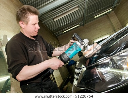 car care work with machine polisher at service station