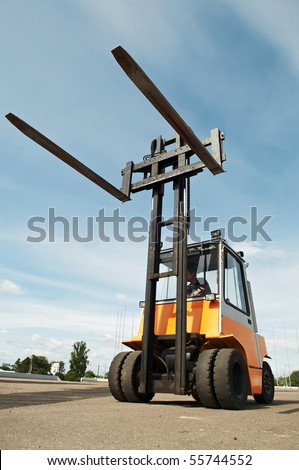 Heavy Forklift loader for warehouse works outdoors with risen forks