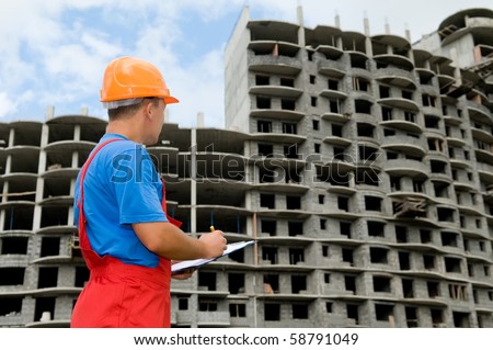 One builder worker with clipboard inspecting works at construction site
