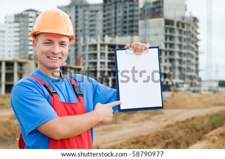 One smiley builder worker pointing the finger to clipboard over construction site