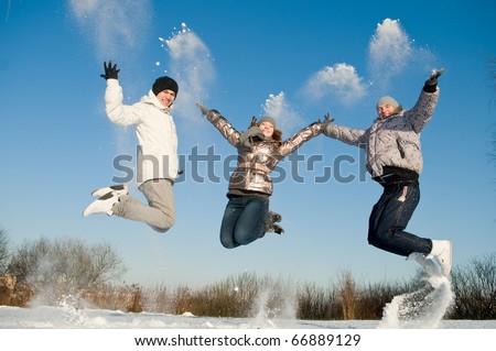 happy young people jumping with snow splashes in winter air
