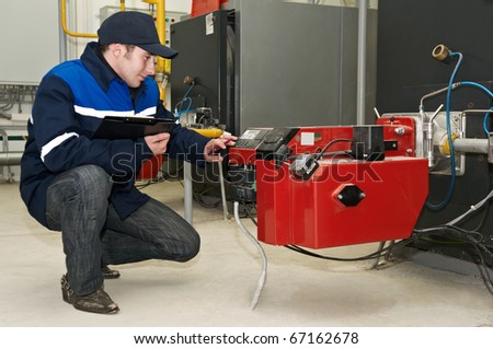 maintenance engineer tuning heating system equipment in a boiler room