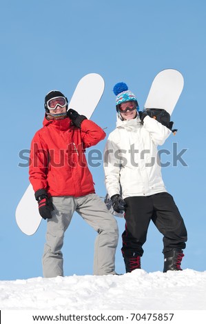 two smiley happy sportsman with snowboards at winter outdoor