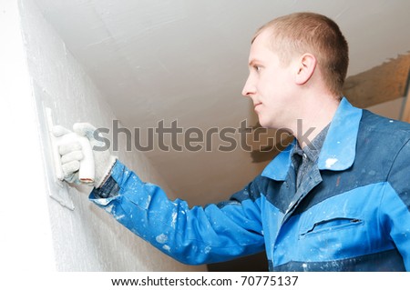 Plasterer at indoor renovation decoration with putty knife