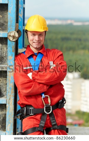 builder worker in uniform with safety belt at construction site