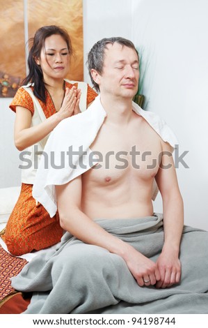 Traditional thai massage health care procedure, kneading back and shoulders muscules of man