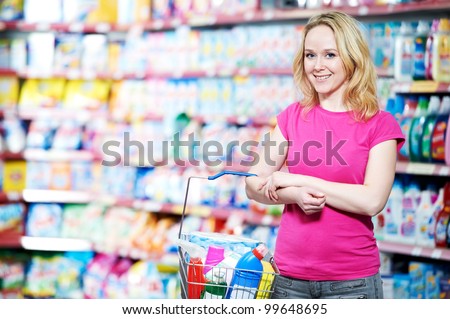 Happy smiling woman in front of household chemistry produces in shopping supermarket