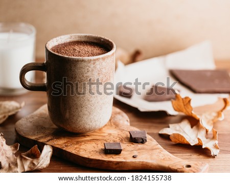 Close-up of hot chocolate in a ceramic mug on the table. Autumn or winter cozy still life.