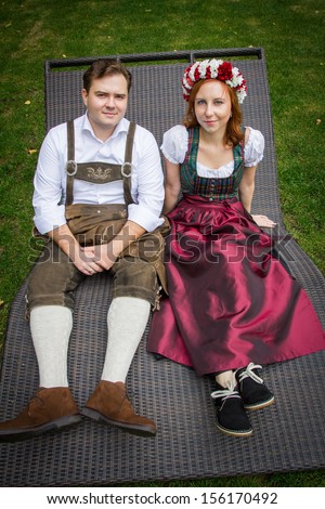 Young couple in Austrian national dress walking in beautiful forest