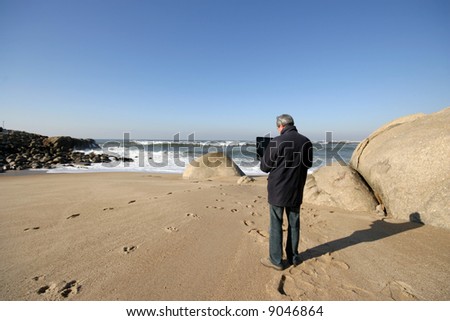mature man working on the beach with portable pc