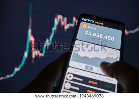 Smartphone with mobile application cryptocurrency wallet. A man analyzes the price chart for bitcoin in a mobile application. The concept of cryptocurrency trading 