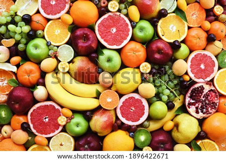 Fresh ripe organic fruits from market: apple and orange, grapefruit and banana, grape and apricot; healthy fruit background