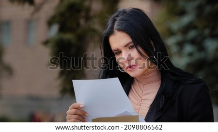 Close-up serious young woman sitting outdoors reading paper letter sad girl feels resentment upset about bad news find out about failed exams college dropout refusal notice financial difficulties Photo stock © 