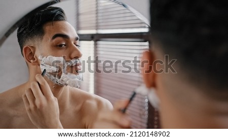 Similar – Image, Stock Photo Handsome bearded man shaving his beard, Young caucasian bearded man trimming beard in home during quarantine. Lifestyle concept.