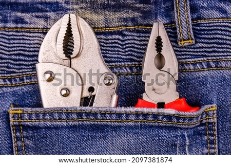 Pliers and locking pliers in rear pocket of jeans. Top view Imagine de stoc © 