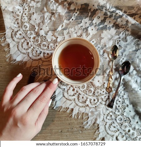 Similar – Foto Bild Teetasse mit schwarzem Tee und Zitrone in einer Hand, dahinter unscharf ein Bücherregal