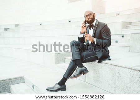 Similar – Image, Stock Photo Elegant black man talking smartphone leaning building