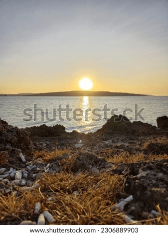 The sun almost sets on the edge of the short cliff of Alak Beach, Kupang City, East Nusa Tenggara Stock fotó © 