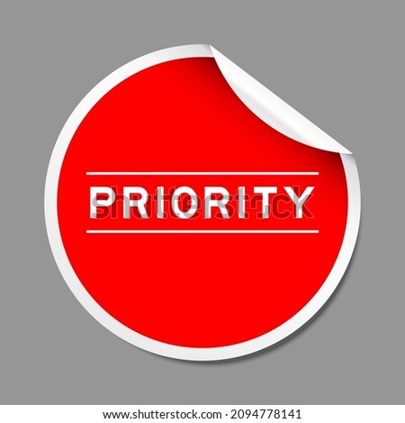 Red color peel sticker label with word priority on gray background