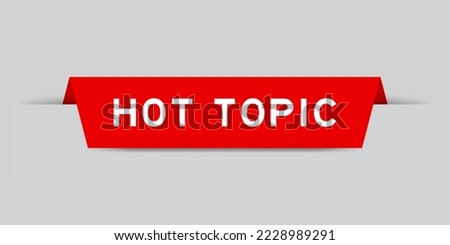 Red color inserted label with word hot topic on gray background