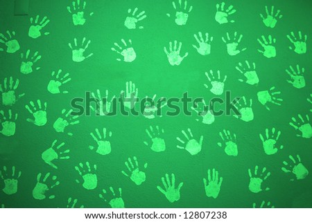 green textured wall with child hands print