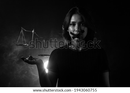 Asian Woman feel injustice, insecure and corruption in society So she closes Mouth with duck tape and show unbalance balance scale, Concept not to say a word. Dark tone environment copy space Foto stock © 