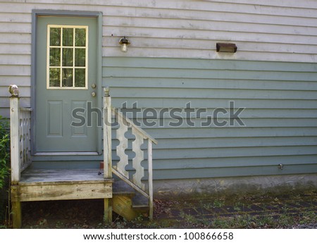 A small set of steps leading up to a small stoop and a doorway