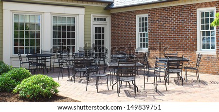 A bunch of outdoor lawn and patio furniture chairs and tables on the back patio outside to be used for outdoor enjoyment and relaxation